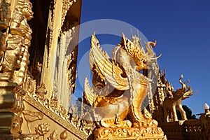 A unique design golden typical Thai style lion statue stands out from the blue sky in central region of Thailand