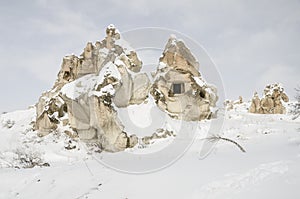 Unique geological rock formations under snow in Cappadocia, Turk