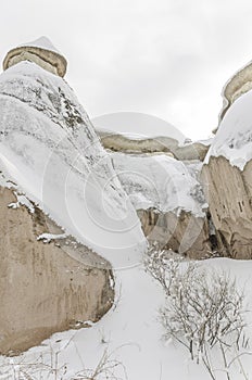 Unique geological rock formations under snow in Cappadocia, Turk