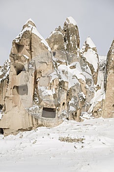 Unique geological rock formations under snow in Cappadocia, Turk