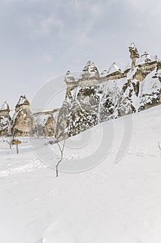 Unique geological rock formations under snow in Cappadocia, Turk