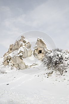 Unique geological rock formations under snow in Cappadocia, Turk