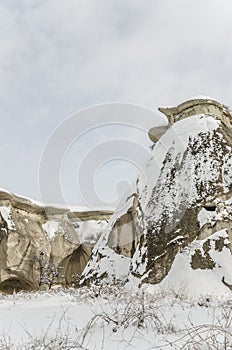 Unique geological rock formations under snow in Cappadocia, Turk