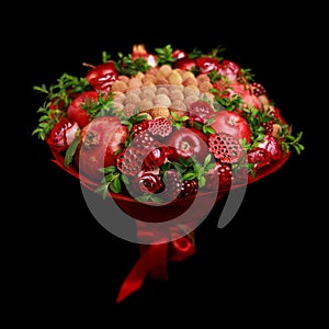 Unique homemade edible bouquet consisting of red fruits and flowers isolated on black background