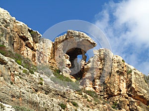 Unique natural rock shade formation at the cliff of Wied Babu Valley in Malta against a blue sky