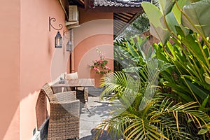 Unique patio area with wooden furniture surrounded by a garden.