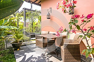 Unique patio area with wooden furniture surrounded by a garden.