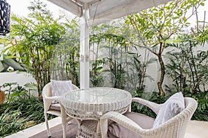 Unique patio area with wooden furniture surrounded by a garden.