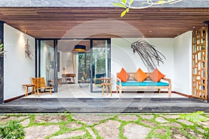 Unique patio area with wooden furniture surrounded by a garden.