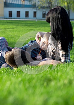 Unique perspective of two loving parents lying on the grass with their baby