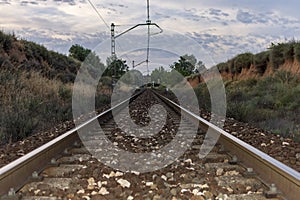 Unique railroad line at the sunset. Train railway track . Low clouds over the railroad