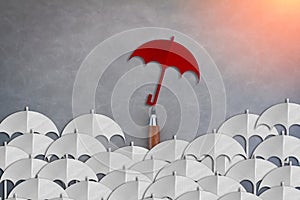 unique red umbrella among another white umbrellas paper cut style