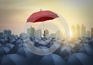 Unique red umbrella among black umbrellas