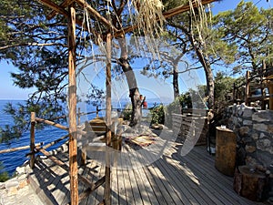 Wooden natural seats and desk with sea view.