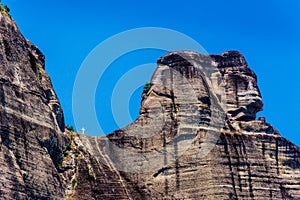 Unique shape formed by hills and white cross of holy trinity at meteora Greece