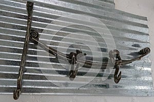 Unique Towl rack with hooks made from old recycled car parts such as shocks and hooks mounted on a piece of corrugated iron