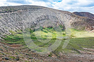 Unique volcanic landscape of green Caldera Blanca volcano crater in Lanzarote, Canary Islands, Spain