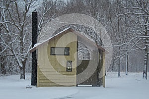 Unisex outhouse in a snowy campground