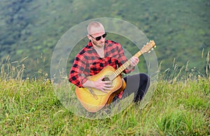 In unison with nature. Keep calm and play guitar. Man with guitar on top of mountain. Acoustic music. Music for soul