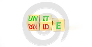 Unite or divide symbol. Concept word Unite or Divide on wooden cubes. Beautiful white table white background. Business unite or