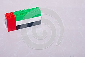 United Arab Emirates flag black, white, green and red made of toy blocks on a tile with a reflection and space to add concept.