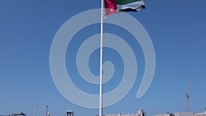 The United Arab Emirates flags waving against the beautiful blue sky