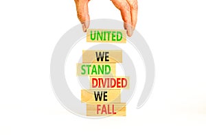 United or divided symbol. Concept words United we stand divided we fall on wooden blocks. Beautiful white table white background.