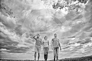 United group purposefully moves forward. Men and woman walks dramatic cloudy sky background. True friendship grow with