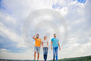 United group purposefully moves forward. Men and woman walks dramatic cloudy sky background. True friendship grow with