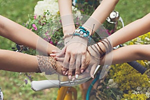 United hands of girlfriends closeup, young girls in boho bracelets