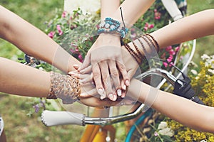 United hands of girlfriends closeup, young girls in boho bracelets