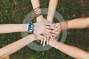 United hands of girlfriends closeup, young girls in boho bracelets