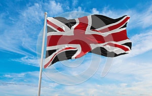 United Kingdom black and red flag at cloudy sky background on sunset, panoramic view. united kingdom of great Britain, England.