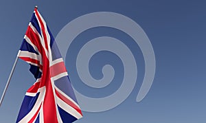 United Kingdom flag on flagpole on blue background. Place for text. The flag is unfurling in wind. Great Britain, London. 3D
