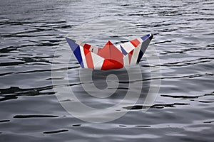 United Kingdom sailing alone in the sea like a paper ship made as the English flag Union Jack - Brexit concept showing England lea