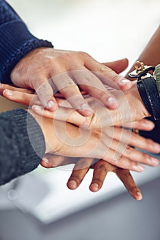 United in the name of business. Closeup shot of a diverse team of colleagues joining their hands together in unity.