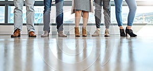 United we stand in business. a group of unrecognizable businesspeople standing in line in an office.