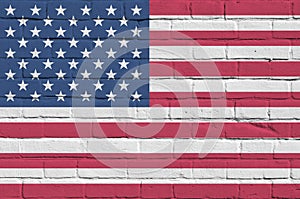 United States of America flag depicted in paint colors on old brick wall. Textured banner on big brick wall masonry background