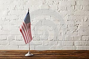 united states of america flagpole on wooden surface against brick wall