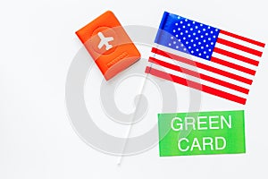 United States of America permanent resident cards. Immigration concept. Text green card near passport cover and US flag