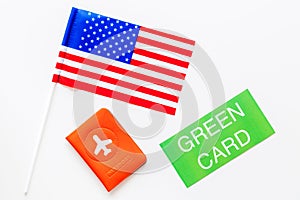 United States of America permanent resident cards. Immigration concept. Text green card near passport cover and US flag