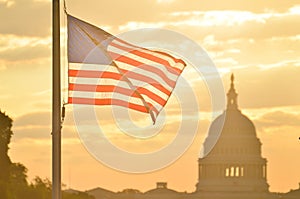 United States Capitol building and US flag silhouette at sunrise, Washington DC