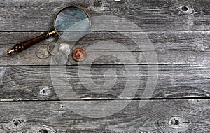 United States collection of vintage coins and an antique magnify glass on rustic wood