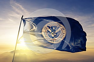 United States Department of Homeland Security flag textile cloth fabric waving on the top sunrise mist fog