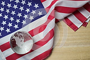 United states flag with crystal glass globe on wood background