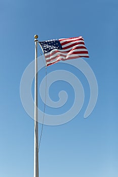 United states flag flowing with a wind on a blue sky background