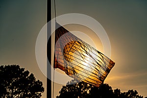 The United States flag waves in the wind at half mast