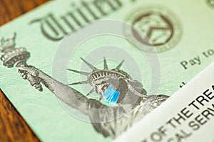 United States IRS Stimulus Check with Statue of Liberty Wearing Medical Face Mask
