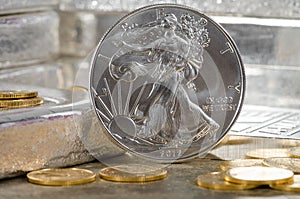 United States Silver Eagle with Gold coins & silver bars in background