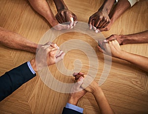 United, support and trust by business people holding hands in a circle from above. Community, teamwork and collaborating